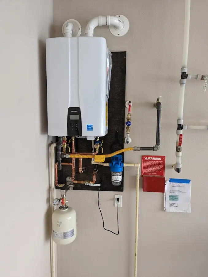 Professional plumber installing copper piping in a New Gloucester home